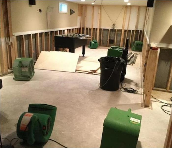 SERVPRO drying equipment in a basement with the framework exposed