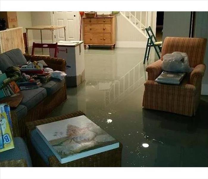 flood water in a room reflecting the ceiling lights, like a pond, wet legs on furniture