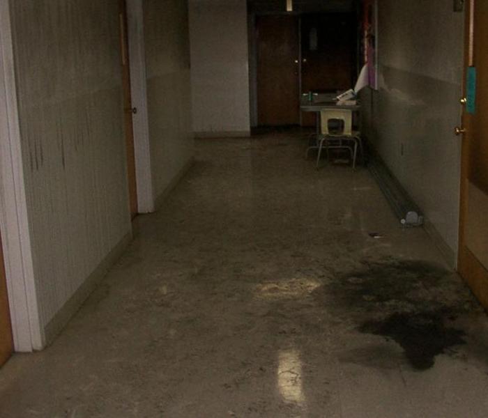 corridor with soot and smoke stains on floor and walls