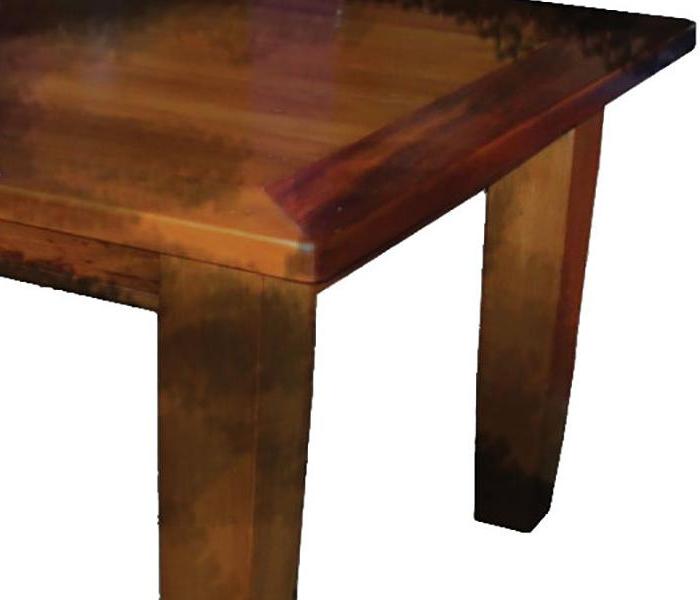 partial view of a soot-covered wooden tabletop and legs