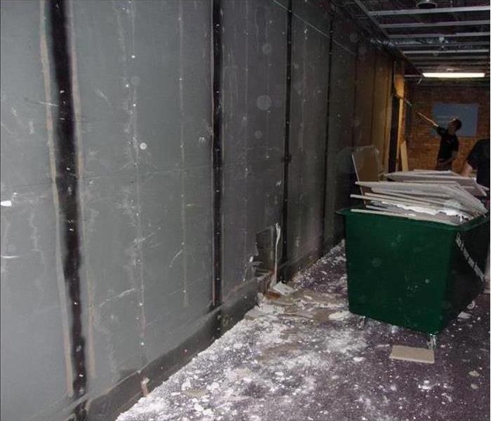 containment wall of plastic sheeting, sheetrock visible in a small dumpster