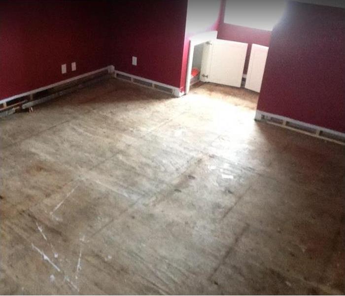 water damaged room; flooring stripped to subfloor; baseboards removed